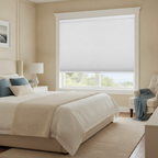 A cozy master bedroom with a bed, nightstands, and a window featuring extended white cellular honeycomb blinds that filter na